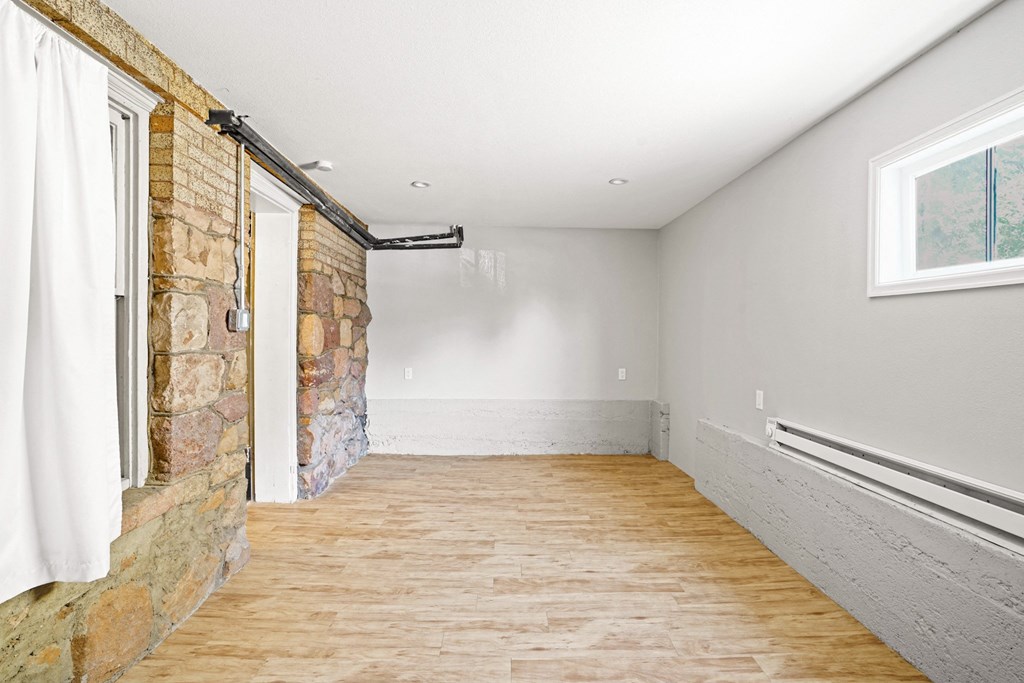 A room with a stone wall and wooden flooring.
