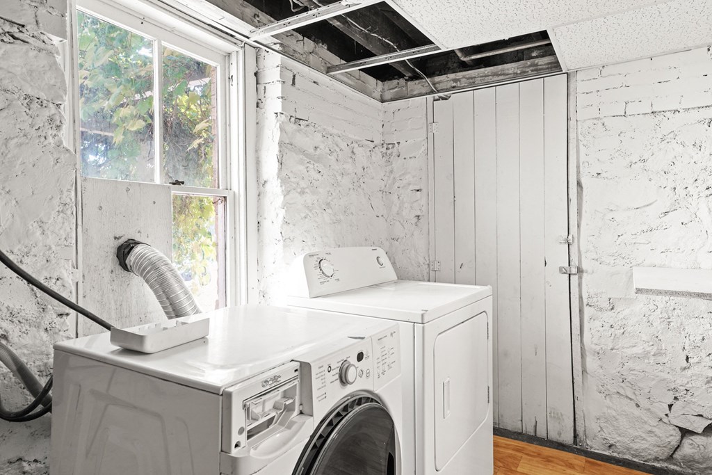 A white washing machine and dryer in a room with white walls.