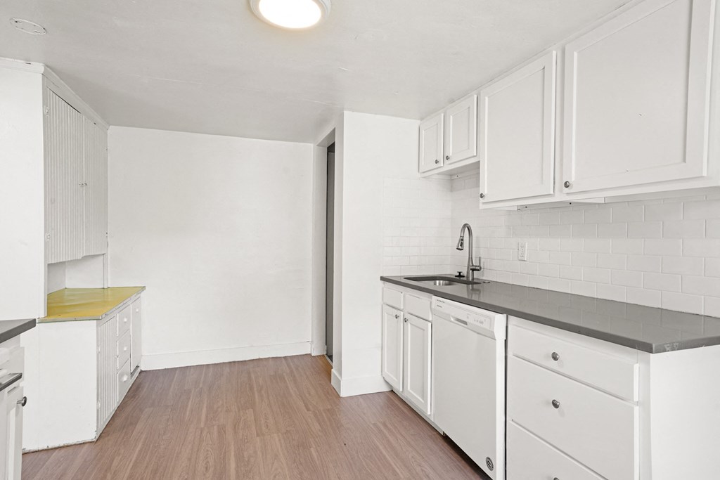 A kitchen with white cabinets and a yellow countertop.