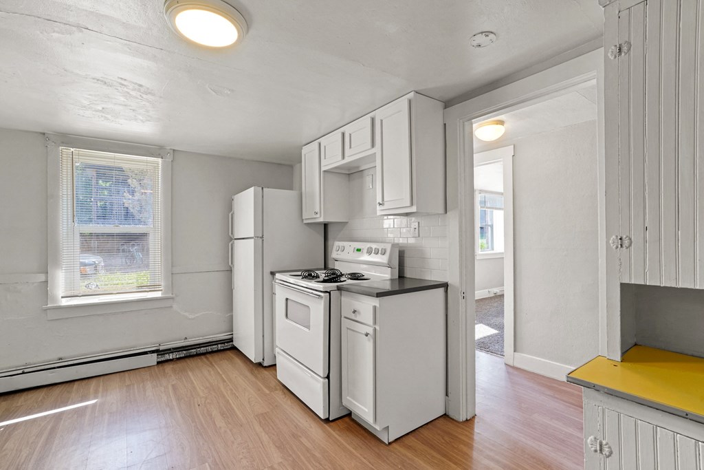 A kitchen with white appliances and cabinets.