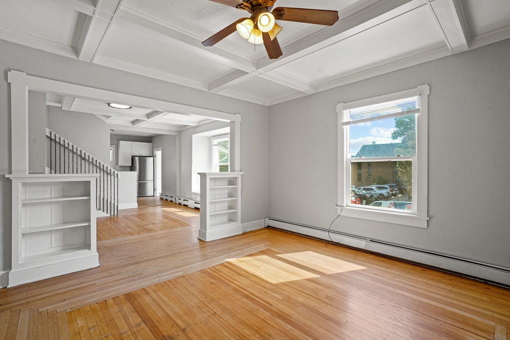 A room with a ceiling fan and a window.