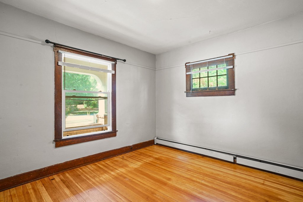 A room with a window and a wooden floor.