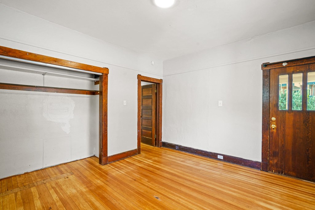A room with a wooden floor and a brown door.