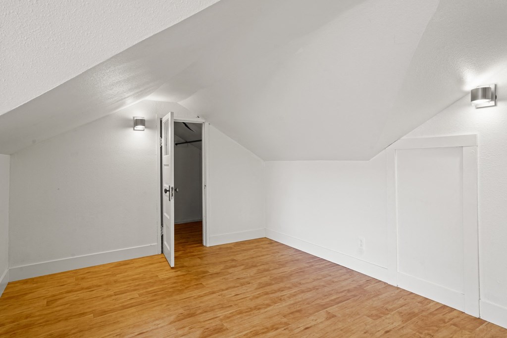 A room with a wooden floor and a white door.