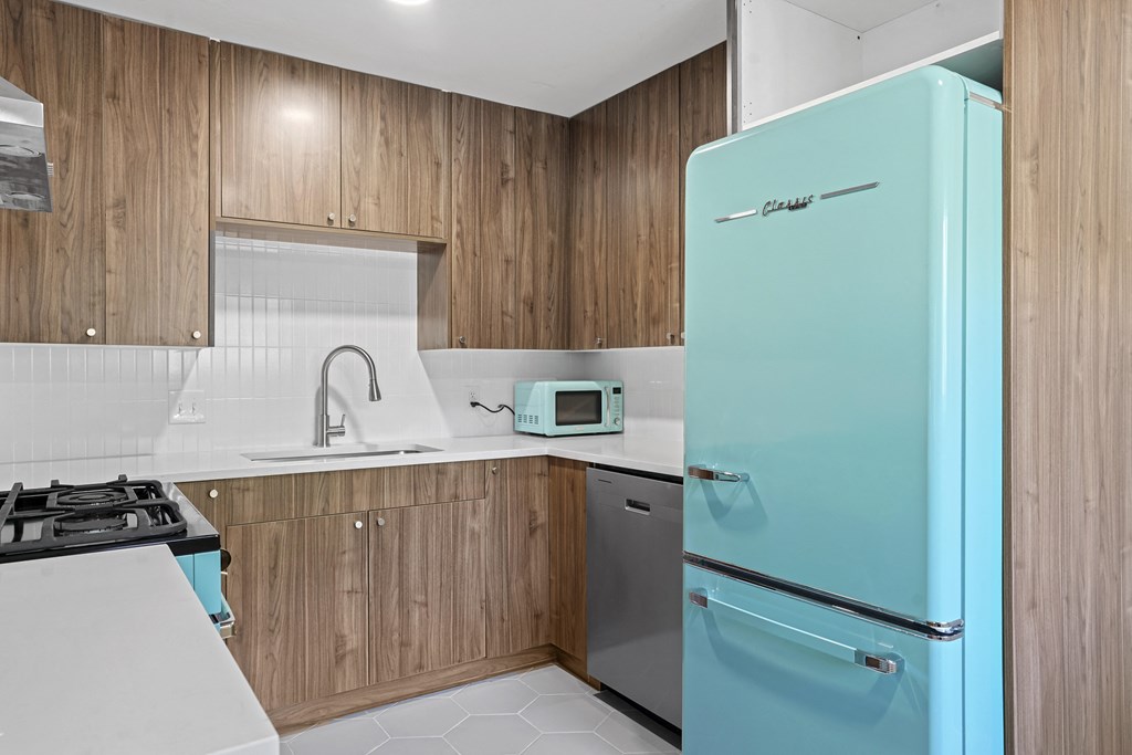 a kitchen with wooden cabinets and a turquoise refrigerator