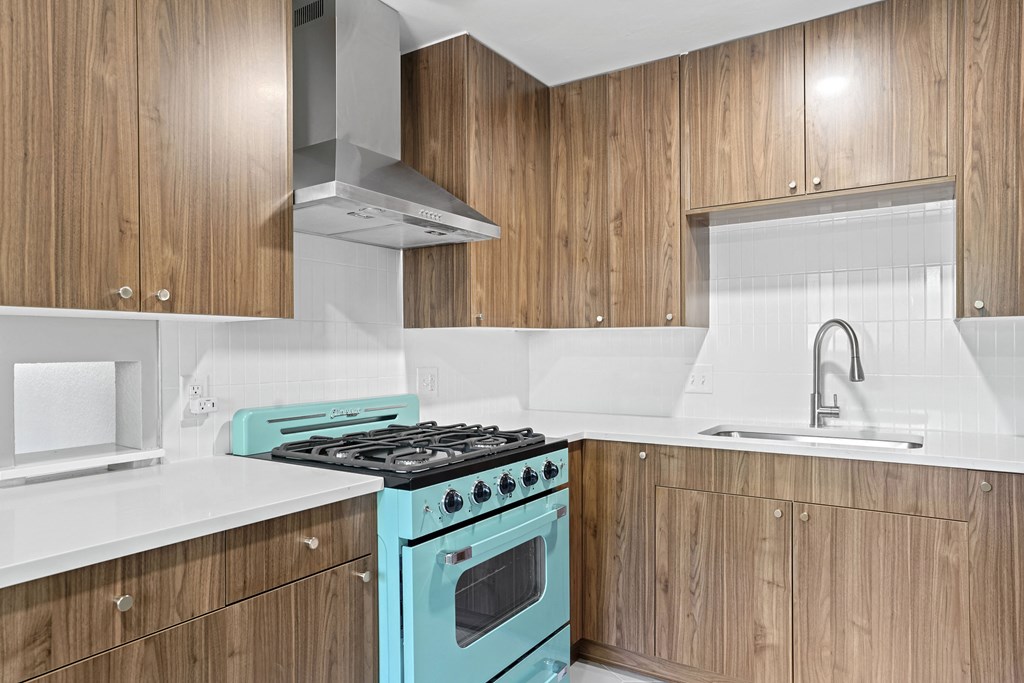a kitchen with a teal stove and white countertops