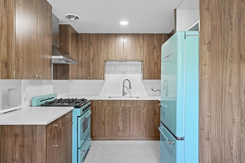 a kitchen with wooden cabinets and a blue refrigerator