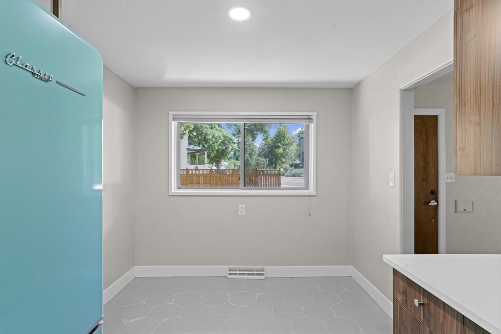 a kitchen with a refrigerator freezer and a window