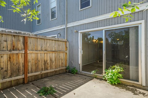 A wooden fence in front of a blue house.