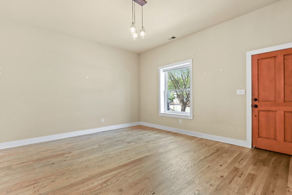 a bedroom with hardwood floors and a wooden door