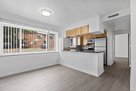 an empty living room and kitchen with a large window