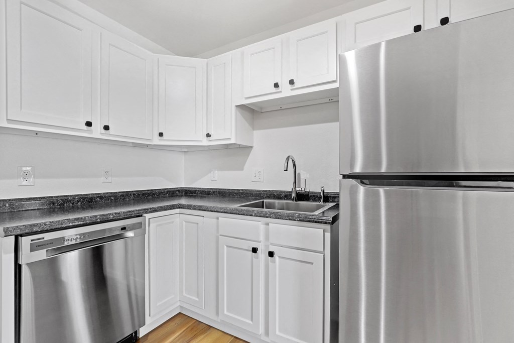 a kitchen with white cabinets and stainless steel appliances