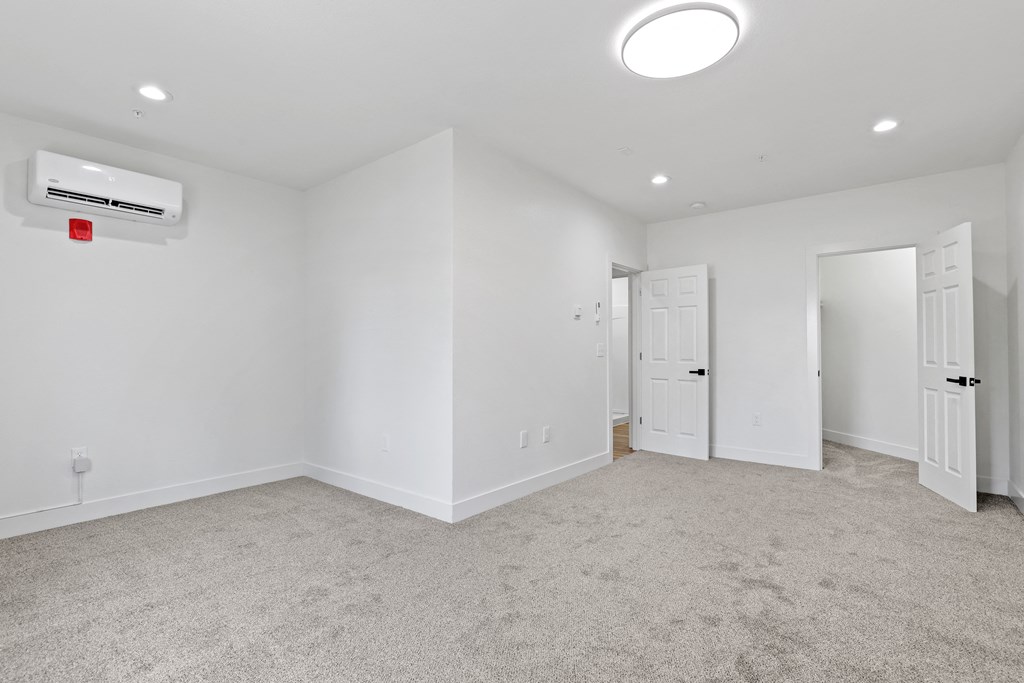 a bedroom with white walls and carpet