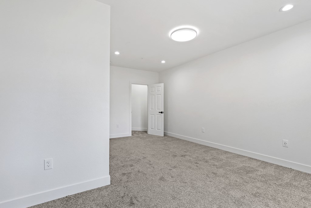 a bedroom with white walls and carpet