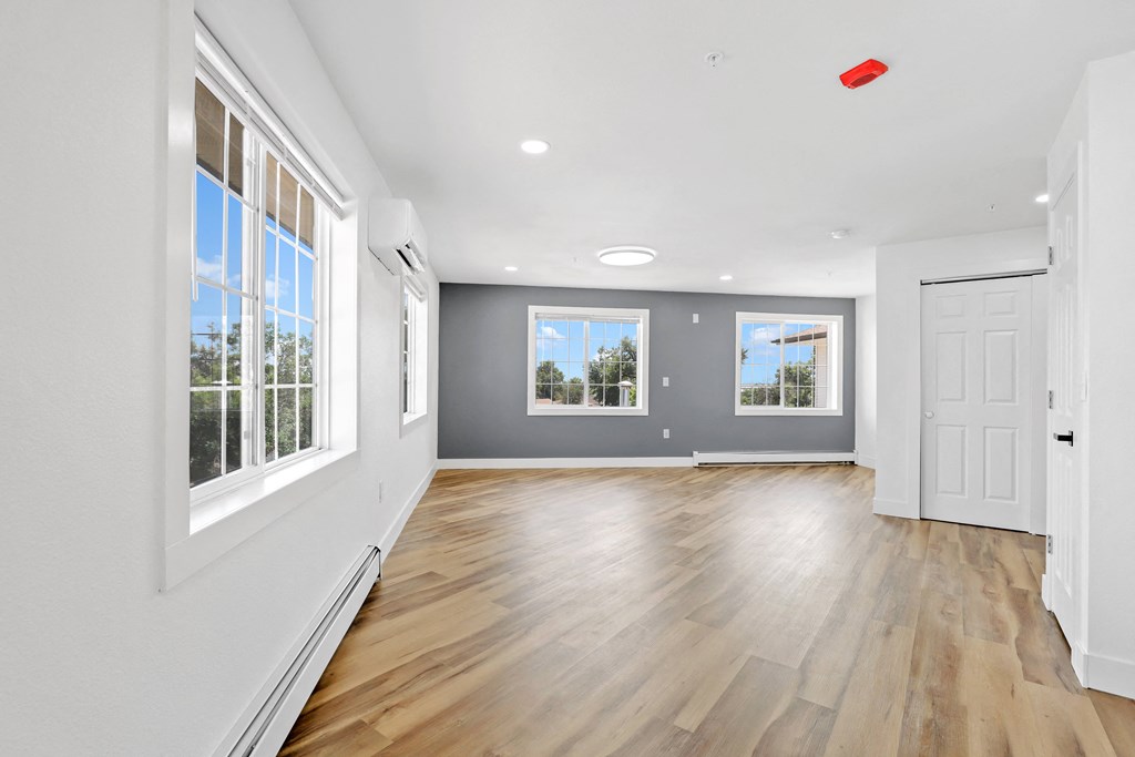 a living room with hardwood floors and grey walls