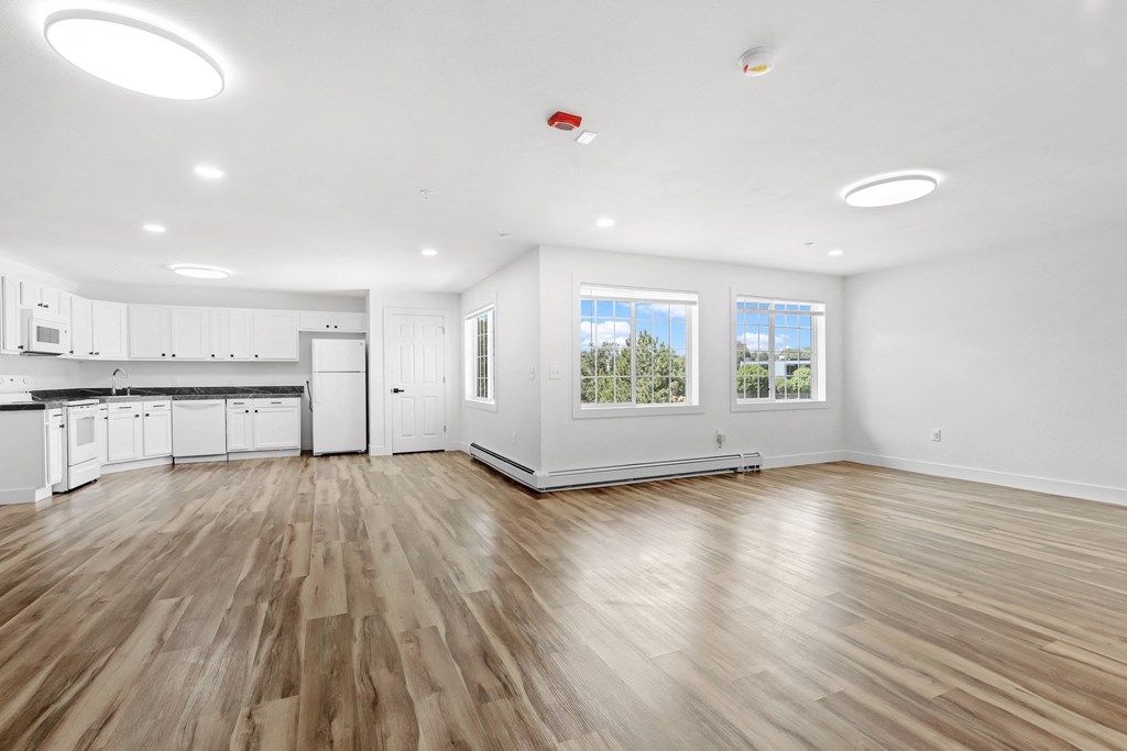 a kitchen and living room with hardwood floors and white walls