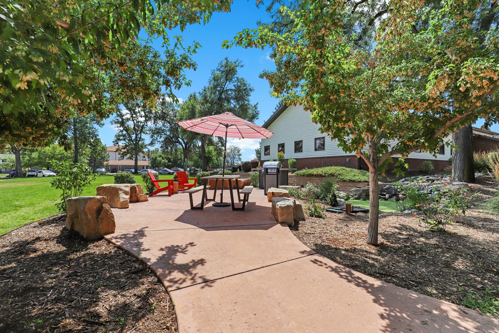 a patio with a table and chairs and a fire pit