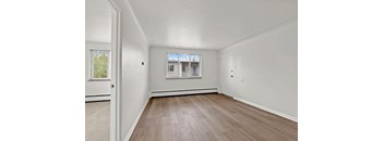 a bedroom with hardwood floors and white walls