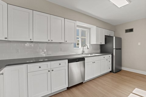 a renovated kitchen with white cabinets and stainless steel appliances