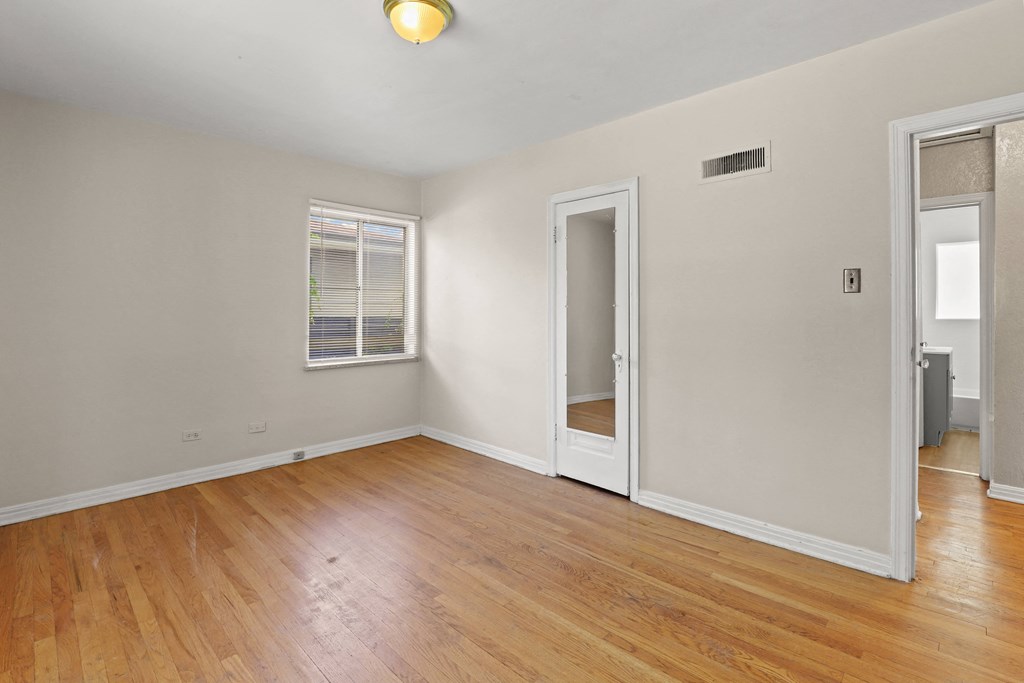 the living room of an empty house with wood floors and white walls