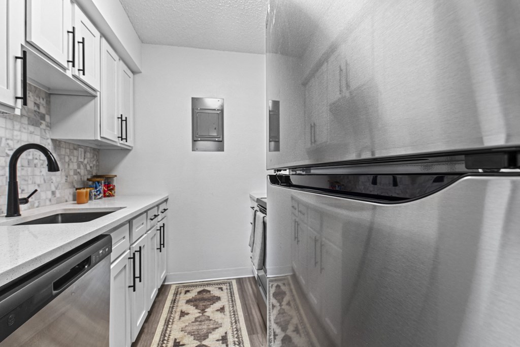 a kitchen with stainless steel appliances and white cabinets