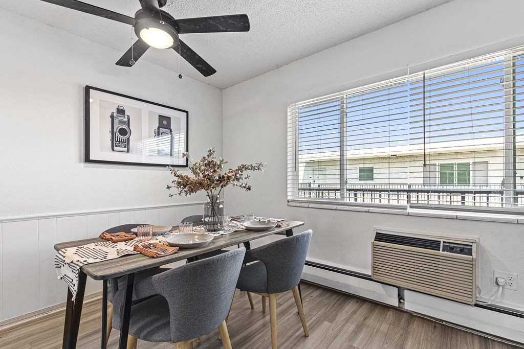 a dining room with a table and chairs and a ceiling fan