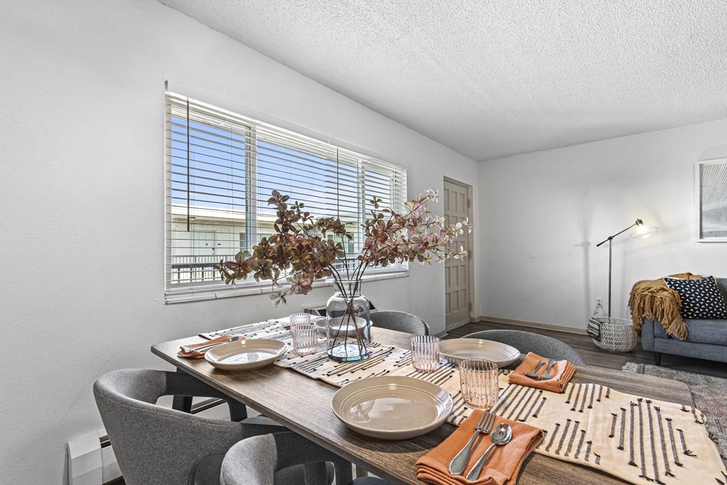 a dining room with a table and chairs and a window