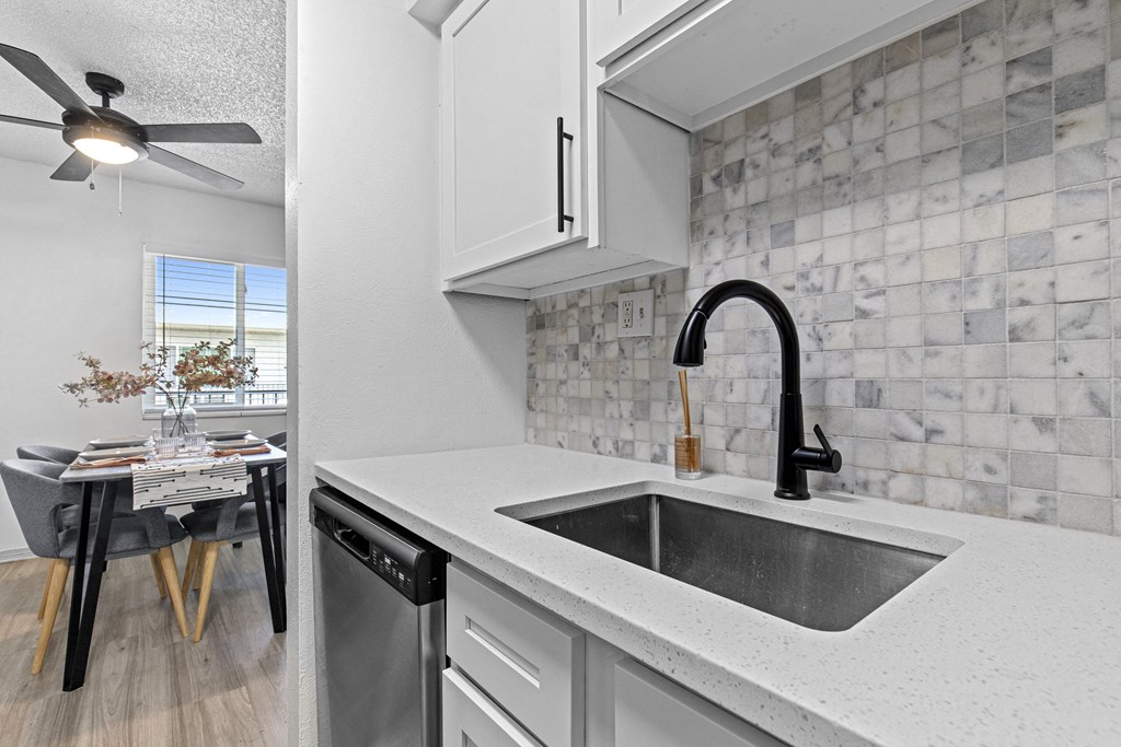 the kitchen and dining area of a house with a sink