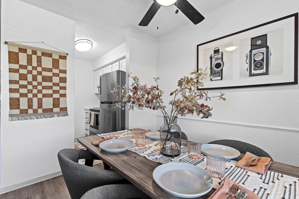 a dining room with a table with plates and chairs
