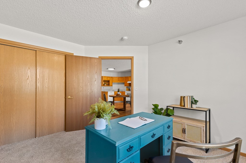 a home office with a blue desk and a blue cabinet