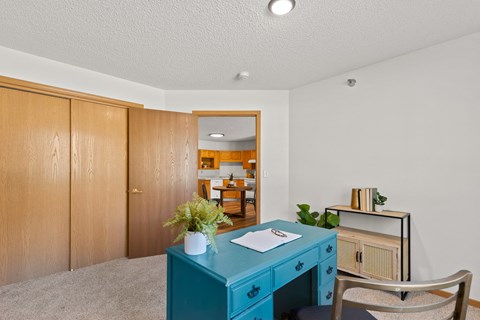 a home office with a blue desk and a blue cabinet