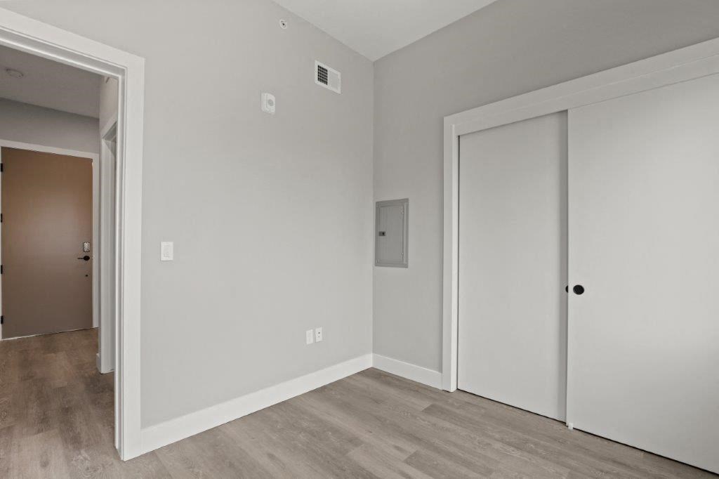 a bedroom with a door to a closet and a wood floor