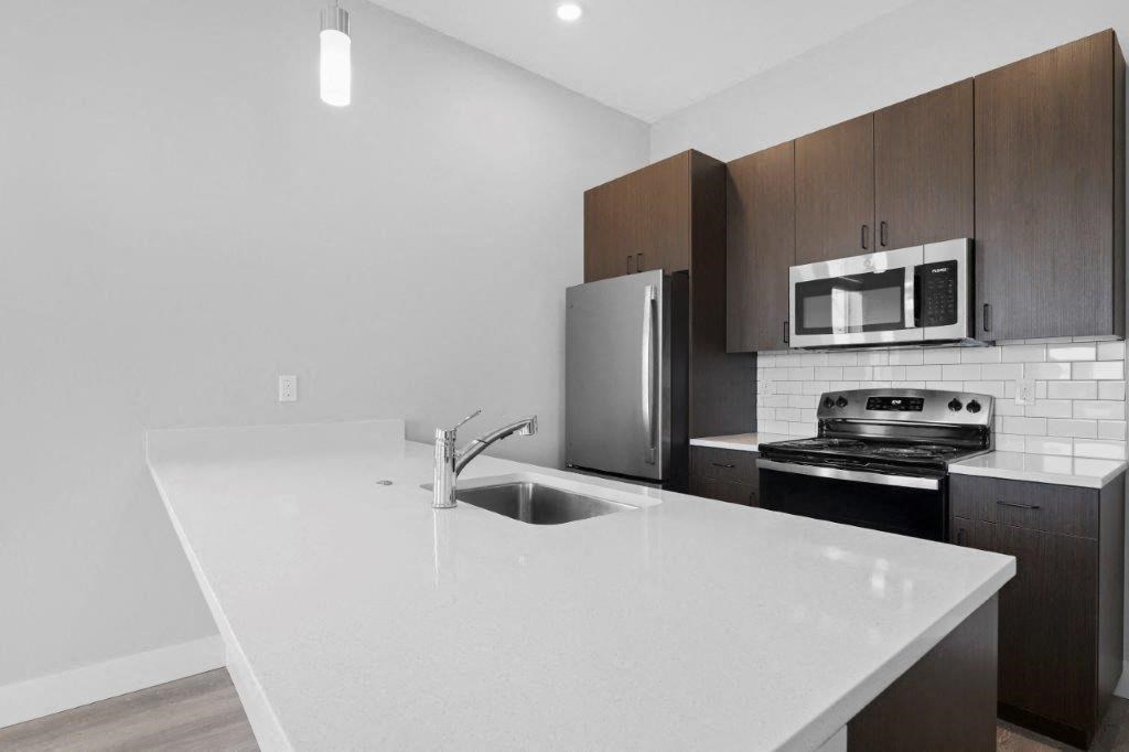 a kitchen with a white counter top and a sink
