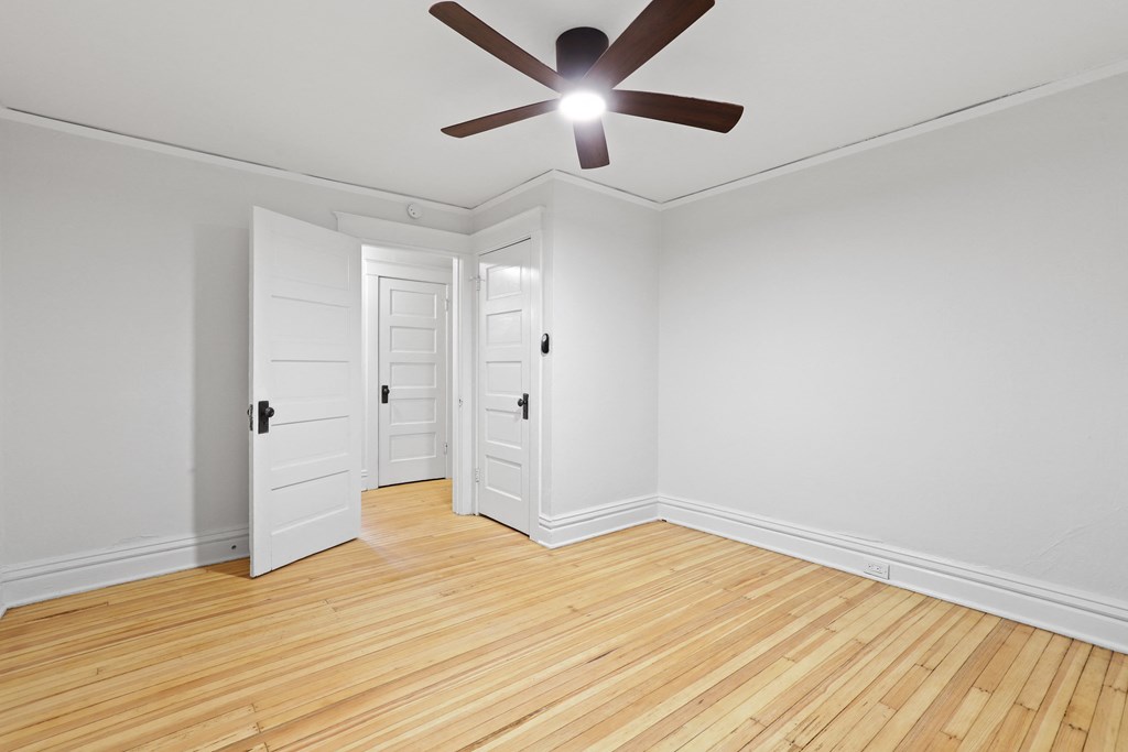 a living room with wood floors and a ceiling fan