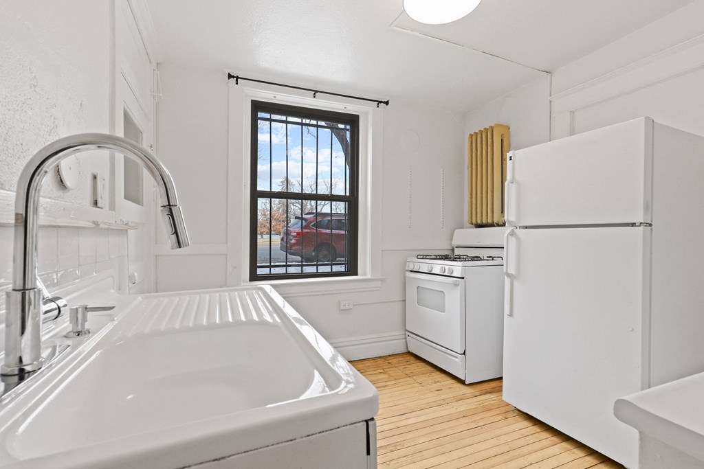 a kitchen with a sink and a refrigerator and a window