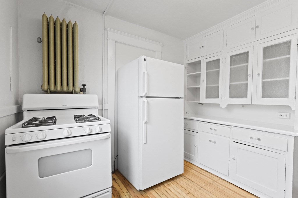 a kitchen with white appliances and white cabinets and a white refrigerator