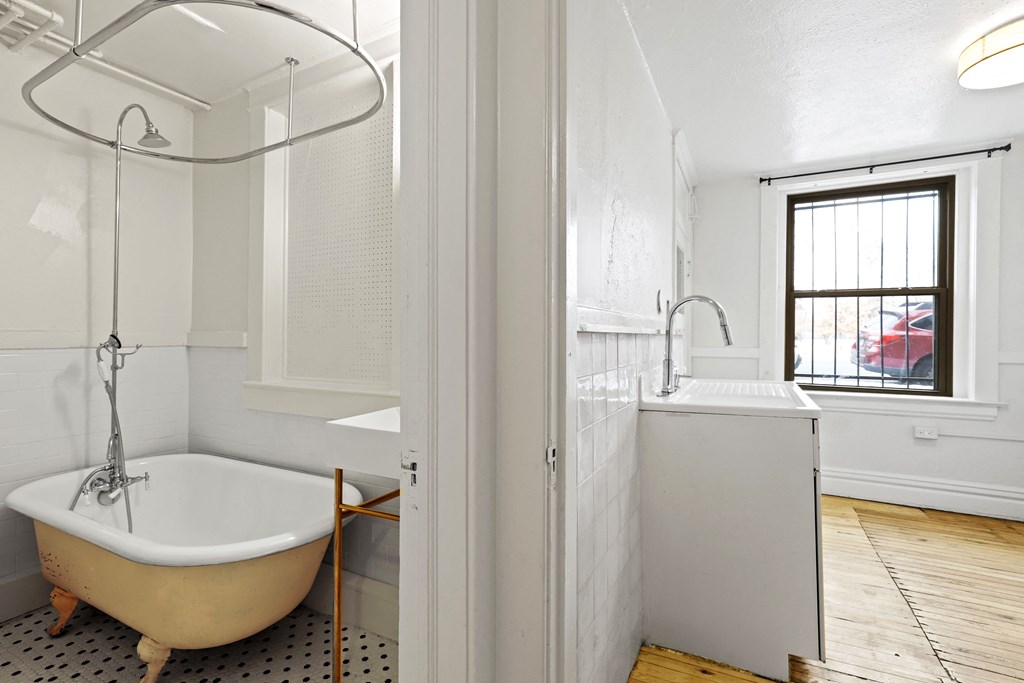 a bathroom with a tub and a sink and a window