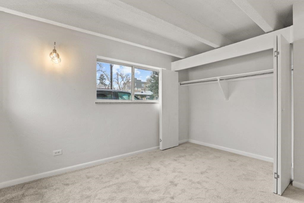 an empty room with a window and a closet