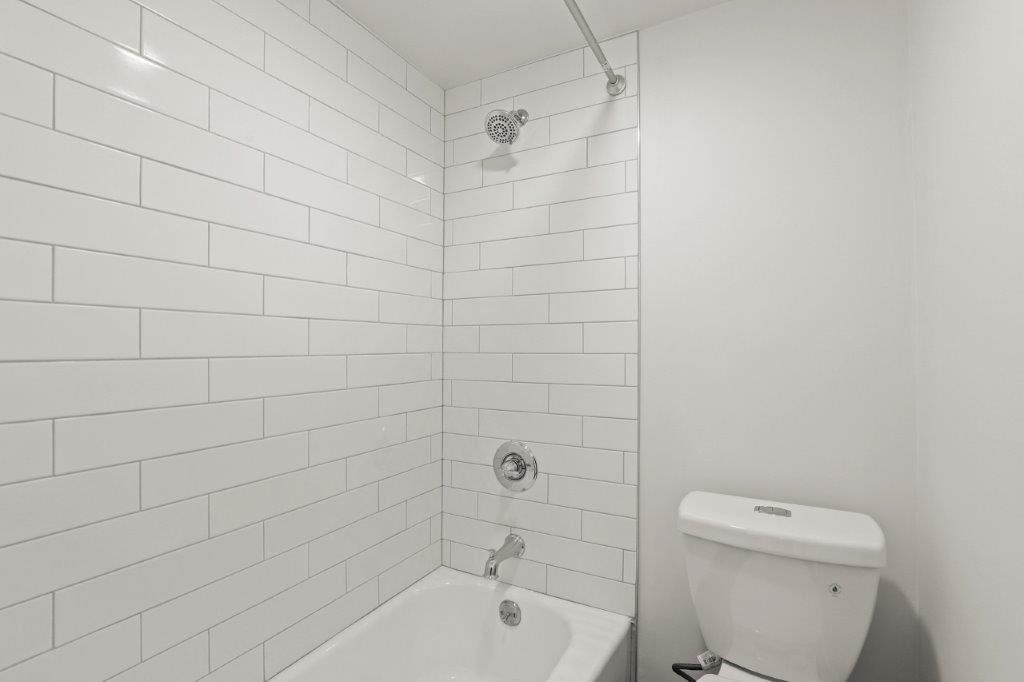 a white bathroom with a toilet and a sink