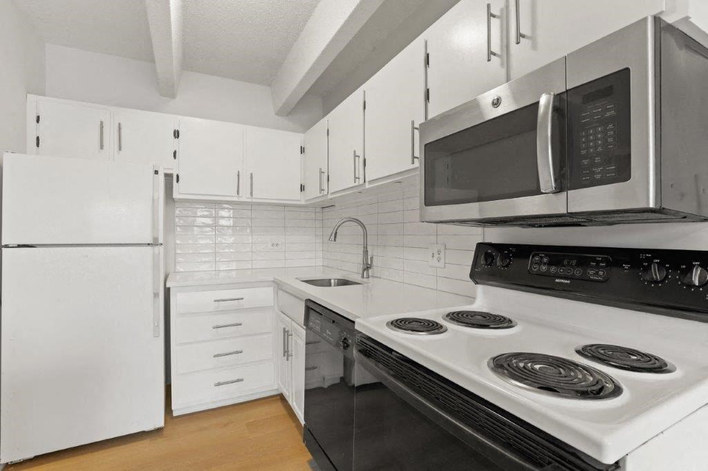 a white kitchen with a stove and a microwave