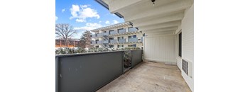 a balcony with a fence and a building in the background
