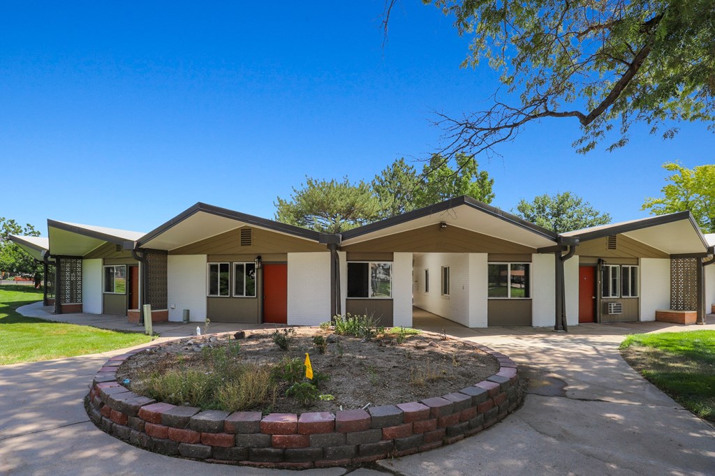 a roundabout in front of two buildings with a tree