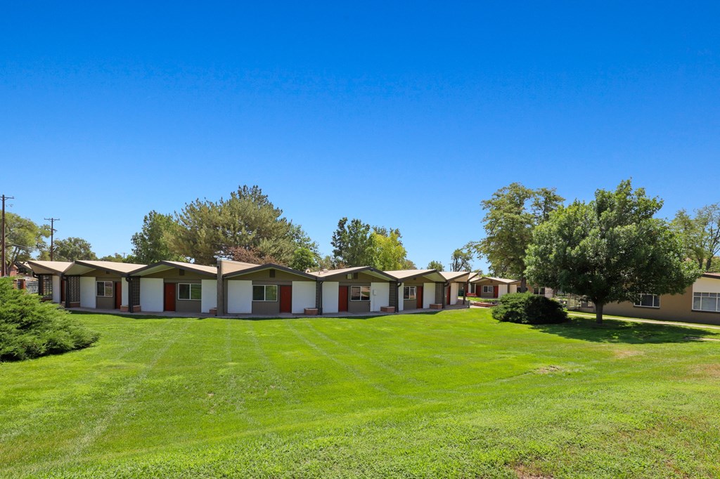 a row of mobile homes in a grassy area with trees