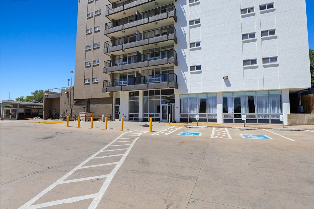 an empty parking lot in front of an apartment building