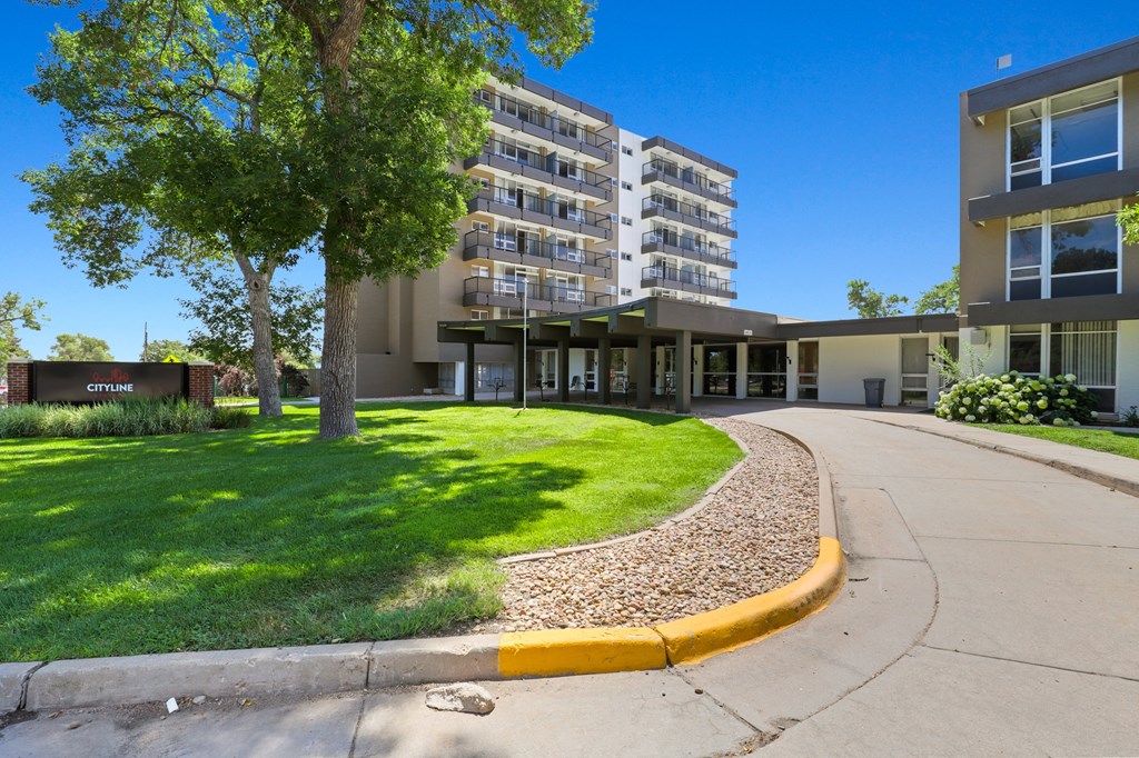 a large building with a lawn and trees in front of it