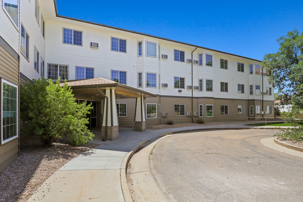 a large white building with a round driveway and an entrance