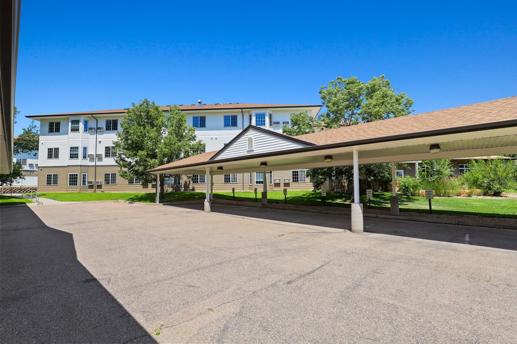 an empty parking lot with an apartment building in the background