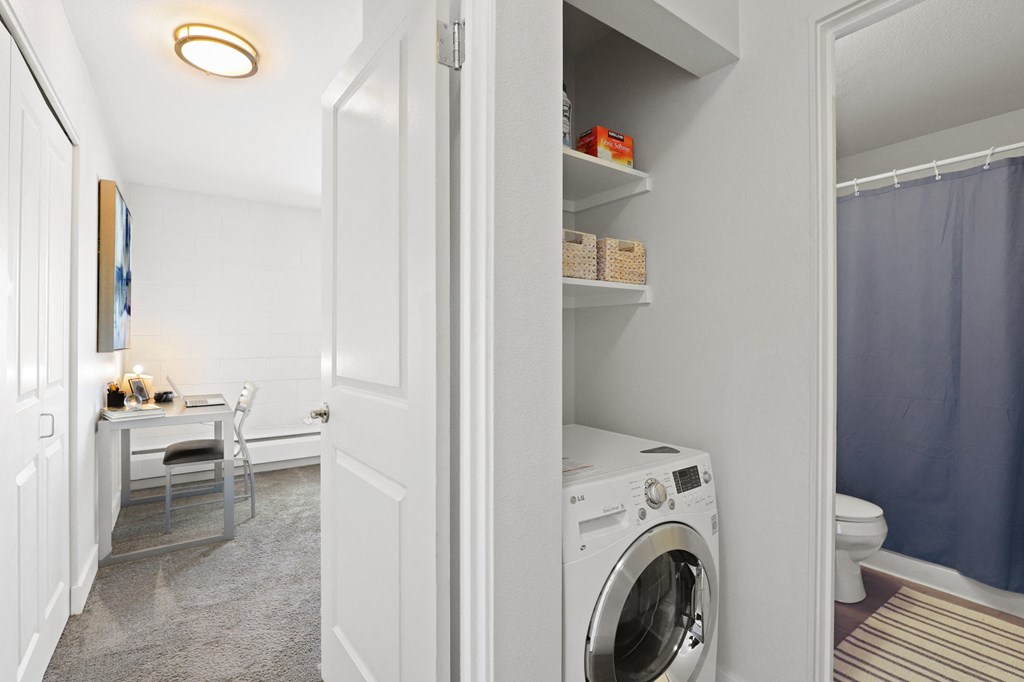 a small laundry room with a washing machine and a toilet