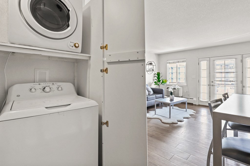 a kitchen with a washer and dryer and a living room with a couch