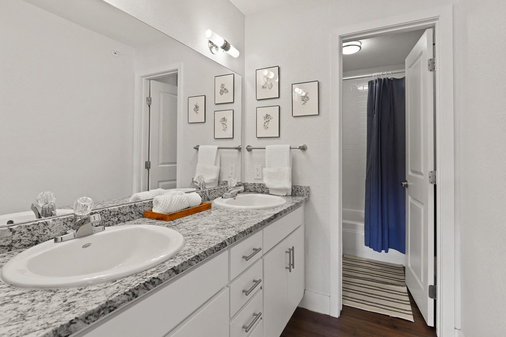 a bathroom with two sinks and a mirror and a shower